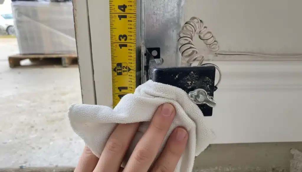 Aligning garage door safety sensors and cleaning photo-eye lenses