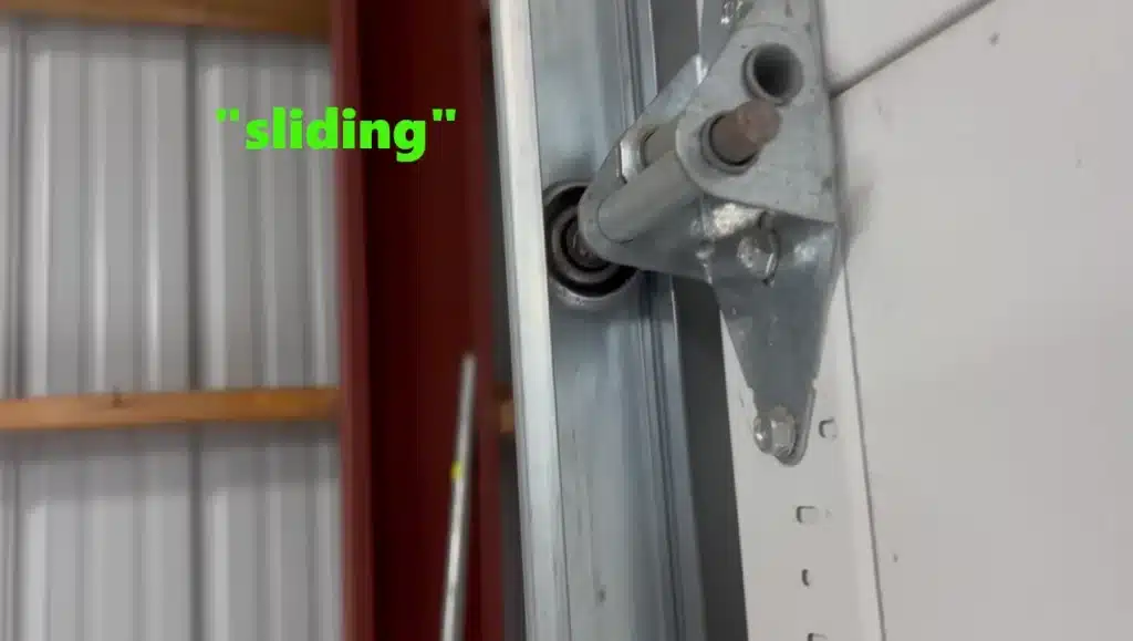 Seized garage door bearing causing friction and drag on metal tracks